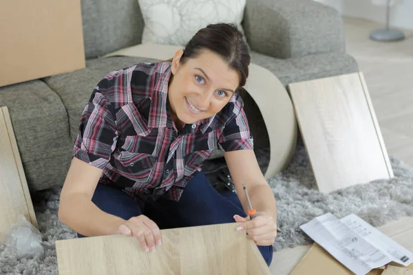 Glückliches Mädchen beim Zusammenbau neuer Möbel — Stockfoto