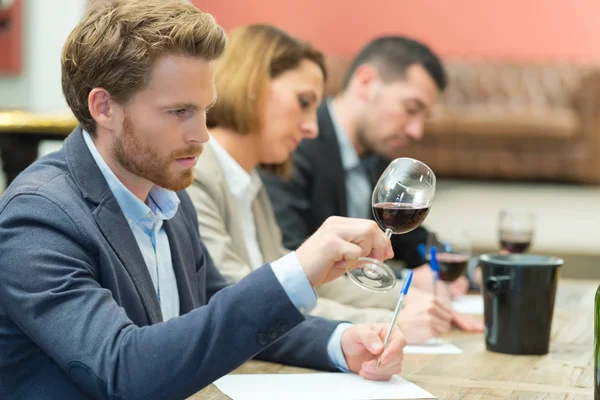 Handsome businessman is tasting red wine with enjoyment — Stock Photo, Image