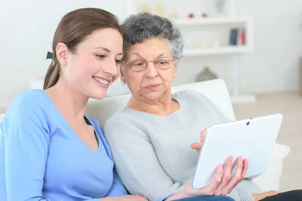 Büyükannesi nasıl dijital tablet kullanılacağını gösteren kadın — Stok fotoğraf