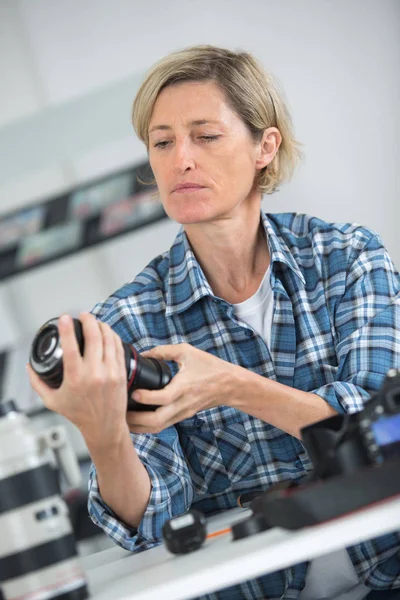 Vrouwelijke technicus reparatie dslr lens — Stockfoto