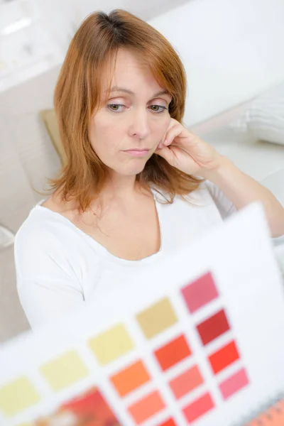 Zdenerwowana kobieta nie lubi kolor z próbki książki — Zdjęcie stockowe