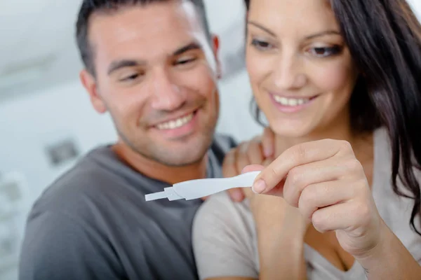 Pár šťastně při pohledu na testování těhotenství — Stock fotografie