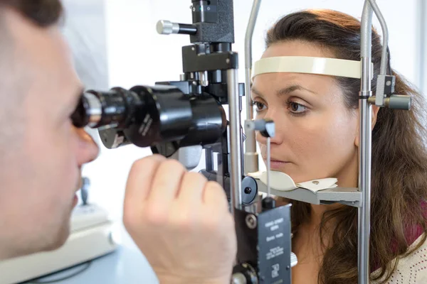 Mujer haciendo pruebas oculares en clínica óptica — Foto de Stock