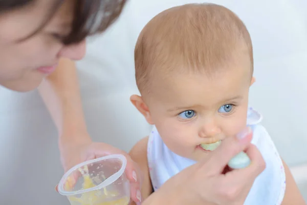 Mum spoon-feeds the child — Stock Photo, Image