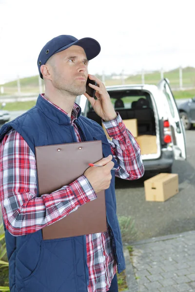Teslimat sürücüsü kullanarak telefon — Stok fotoğraf