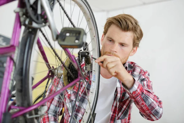 Man som arbetar på bakhjulet på en cykel — Stockfoto