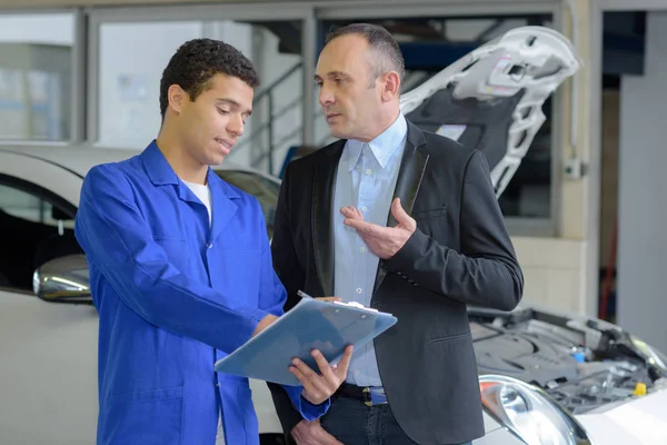 Mechanic and client in car service — Stock Photo, Image