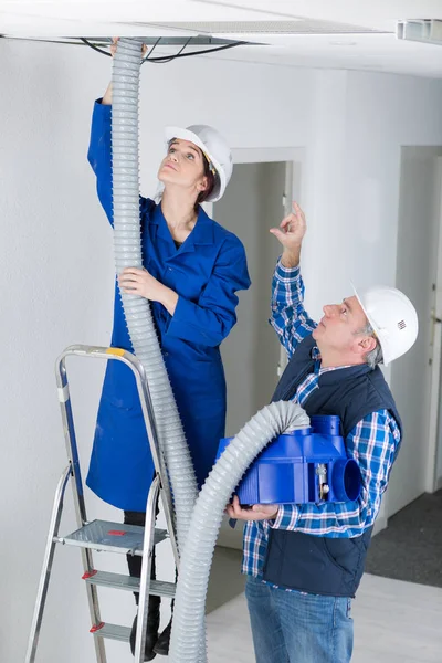Twee elektriciens werken aan het plafond — Stockfoto