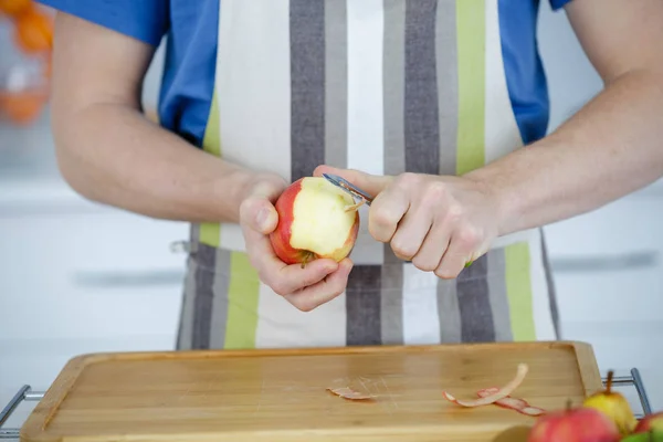 Άνθρωπος ξεφλούδισμα ένα μήλο — Φωτογραφία Αρχείου