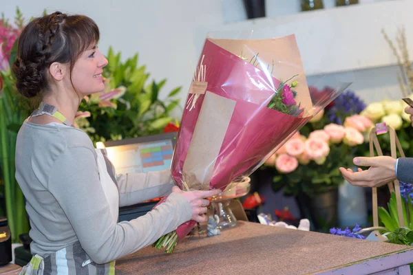Kobiece Kwiaciarnia dając bukiet do klienta Obrazek Stockowy