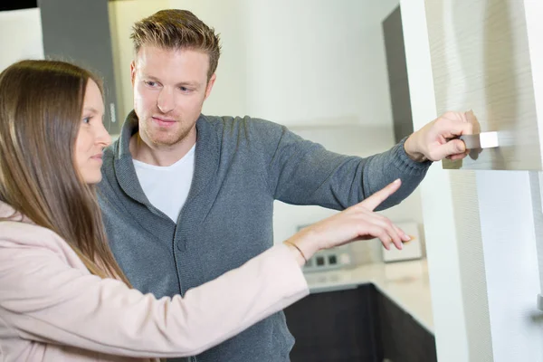 Paar schaut auf Küchenschränke — Stockfoto