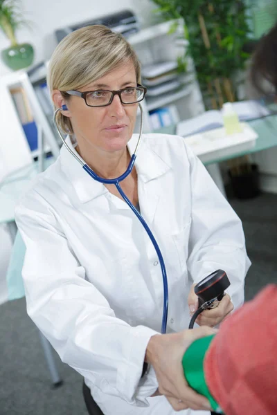 Doctora tomando presión arterial —  Fotos de Stock