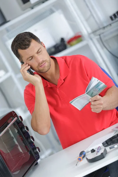 Reparateur op de telefoon met een cliënt — Stockfoto