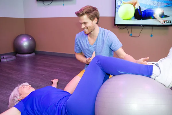 Senior woman doing pilates with physical therapist — Stock Photo, Image