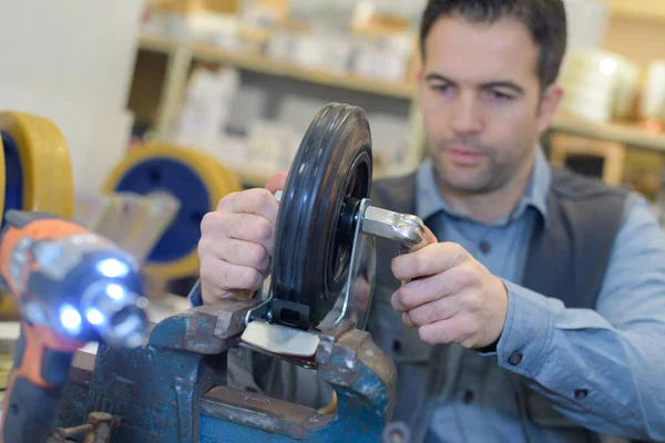 Metalen trolley wielen en man — Stockfoto