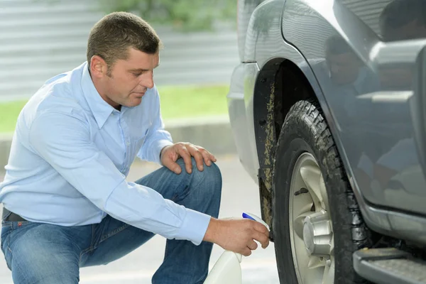Middle age classy man cleaning his car wheels — Stock Photo, Image
