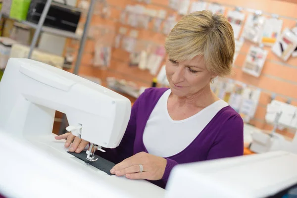 Signora anziana utilizzando macchina da cucire — Foto Stock