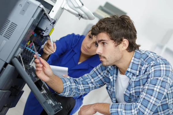 Dois jovens técnicos reparando impressora — Fotografia de Stock