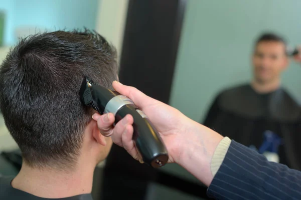 Kadeřnice stříhat vlasy muže s zastřihovač vlasů — Stock fotografie
