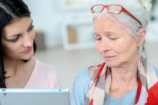 Pielęgniarka pomaga to stara kobieta i jej codziennych zadań zarządzania — Zdjęcie stockowe