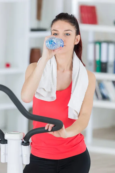 Schöne junge Frau mit einer Flasche Wasser in den Händen — Stockfoto