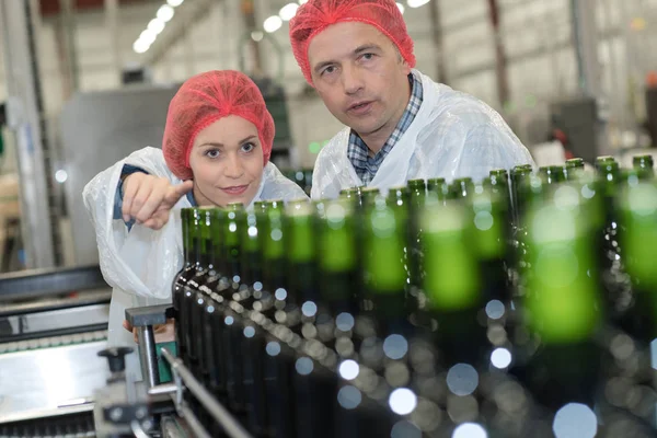 Trabajadores que comprueban una cinta transportadora en fábrica —  Fotos de Stock