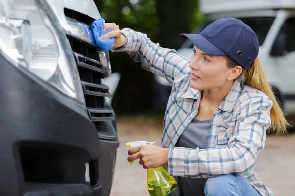 Frau wäscht Autoscheinwerfer von Hand — Stockfoto
