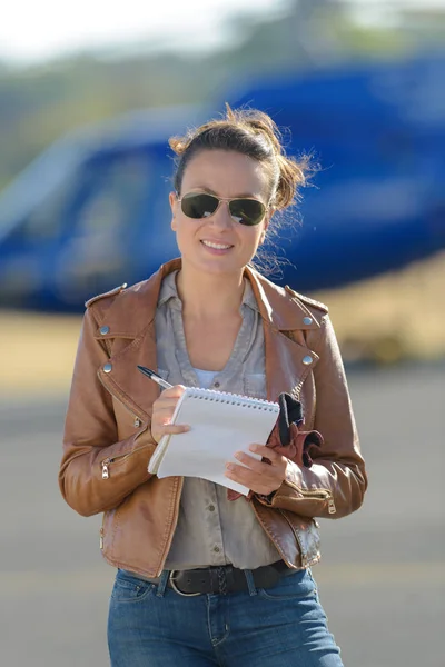 Молода жінка пілотний вертоліт записує нотатки — стокове фото