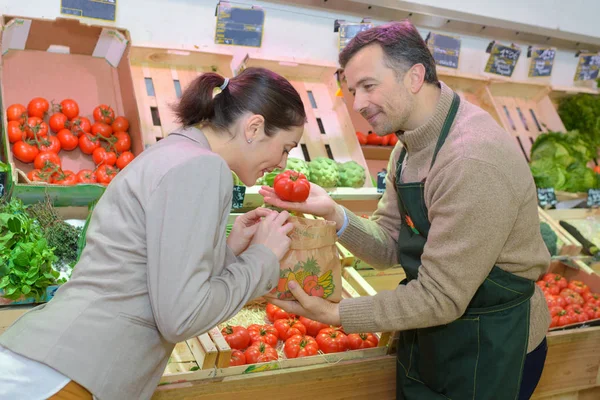 Tetero sosteniendo tomate para que el cliente huela —  Fotos de Stock