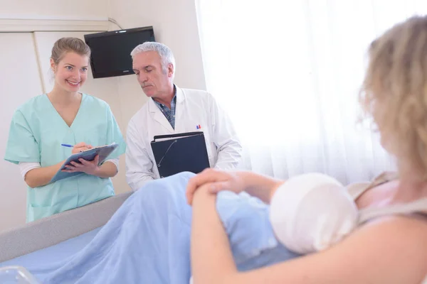 Bebé recién nacido en la sala de parto con mamá enfermera médico —  Fotos de Stock