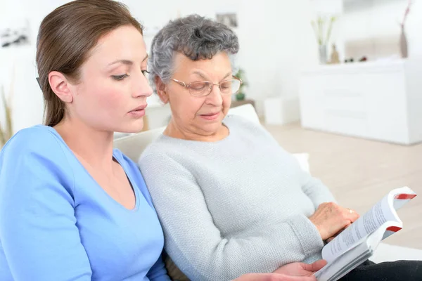 Mother and daughter sitting on the sofa — Stock Photo, Image