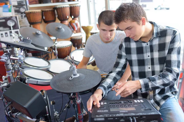 Молодые люди с электронным барабанным комплектом и усилителем — стоковое фото