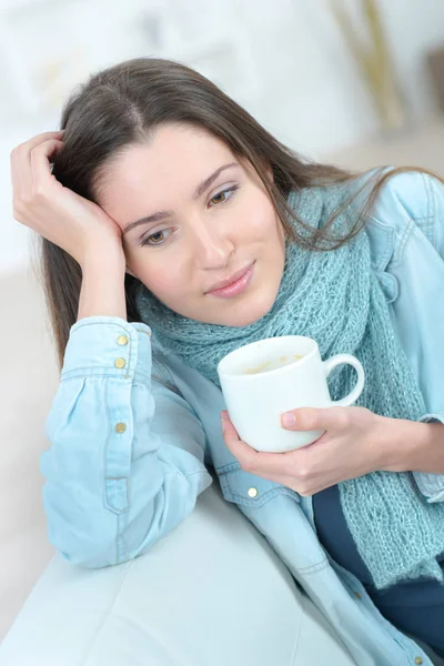 Vacker ung kvinna withcoffee avkopplande på soffan — Stockfoto