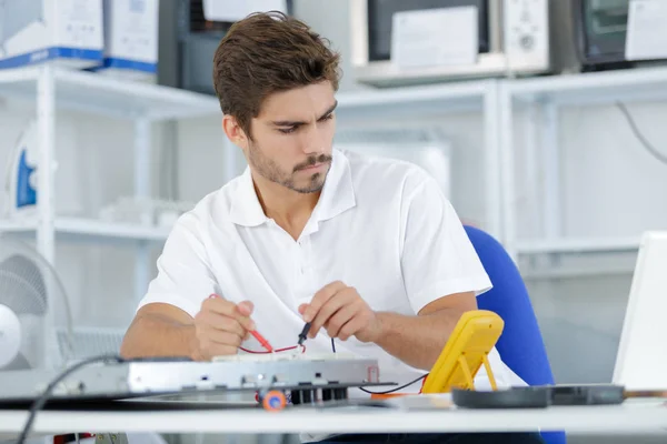 Handsome electrician testing induction hobs — Stock Photo, Image