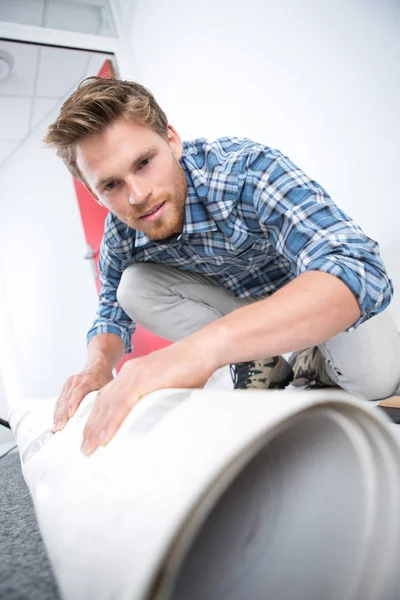 家の床に若い男性ワーカー ループ カーペット — ストック写真