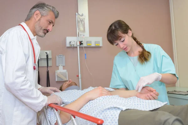 Équipe médicale inspectant les blessures des patients — Photo