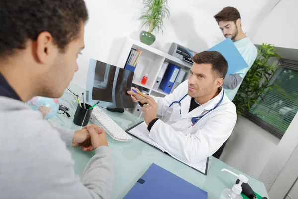 Lekarz i pacjent o czymś rozmawiają. — Zdjęcie stockowe