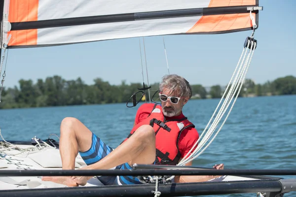Man segling och drömmar på floden vid sommardag — Stockfoto