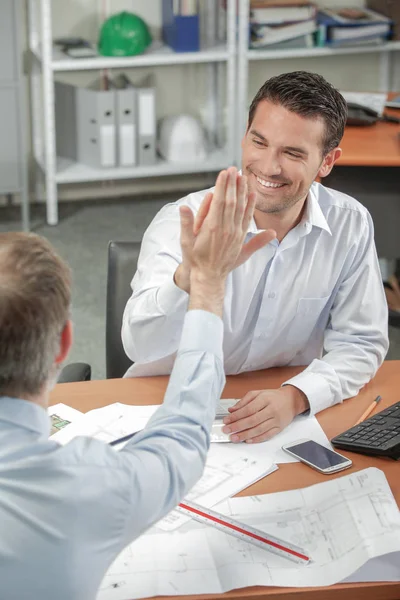 Män som har en hög fem inuti ett kontor — Stockfoto