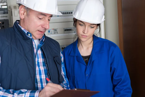 Elektricien en zijn jonge vrouwelijke leerling — Stockfoto