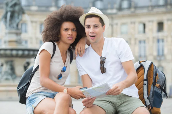 Turistas felices con mapa ciudad turística — Foto de Stock