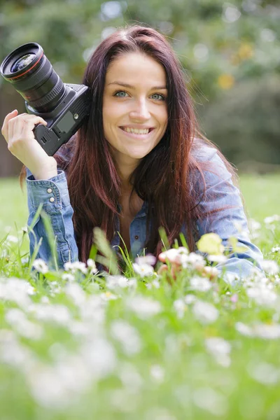 Jonge vrouwelijke fotograaf schieten in een groene natuurlijke omgeving — Stockfoto