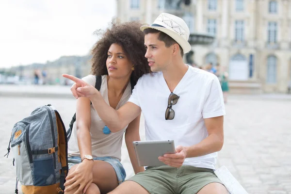 Молодая пара туристов, глядя на экран планшета на открытом воздухе — стоковое фото
