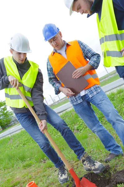 Builders at green field — Stock Photo, Image