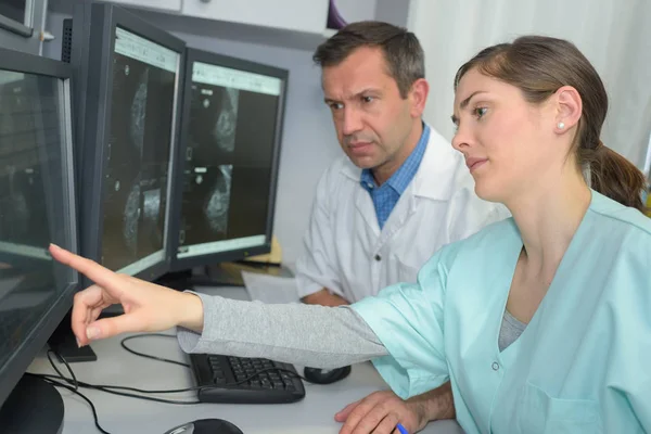 Médico e técnico analisando raios X cerebrais no computador — Fotografia de Stock