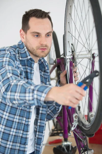 Mecánico trabajando en rueda de bicicleta — Foto de Stock