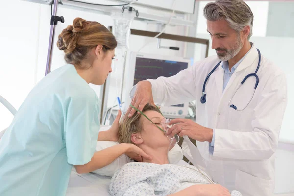 Bayan hasta, hastane için oksijen maskesi veren doktor — Stok fotoğraf