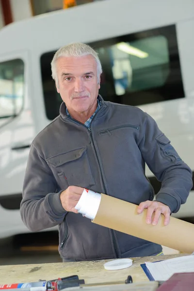 Lavoratore che prende carta dal rotolo di cartone — Foto Stock