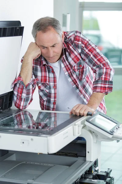 Printer checking a print run at table — Stock Photo, Image