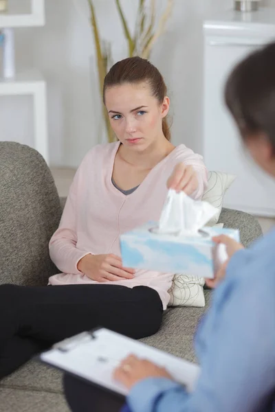 Jonge vrouw trekken van een weefsel uit de doos — Stockfoto